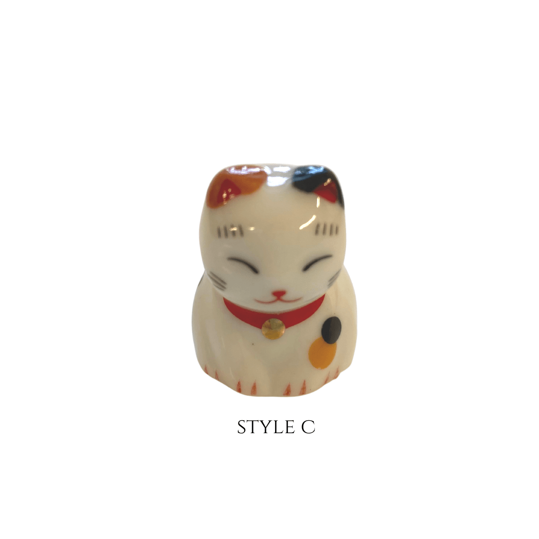 Decorative cat figurine with a red collar on a white background
