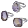 Three silver ametrine rings with purple gemstones on a white background