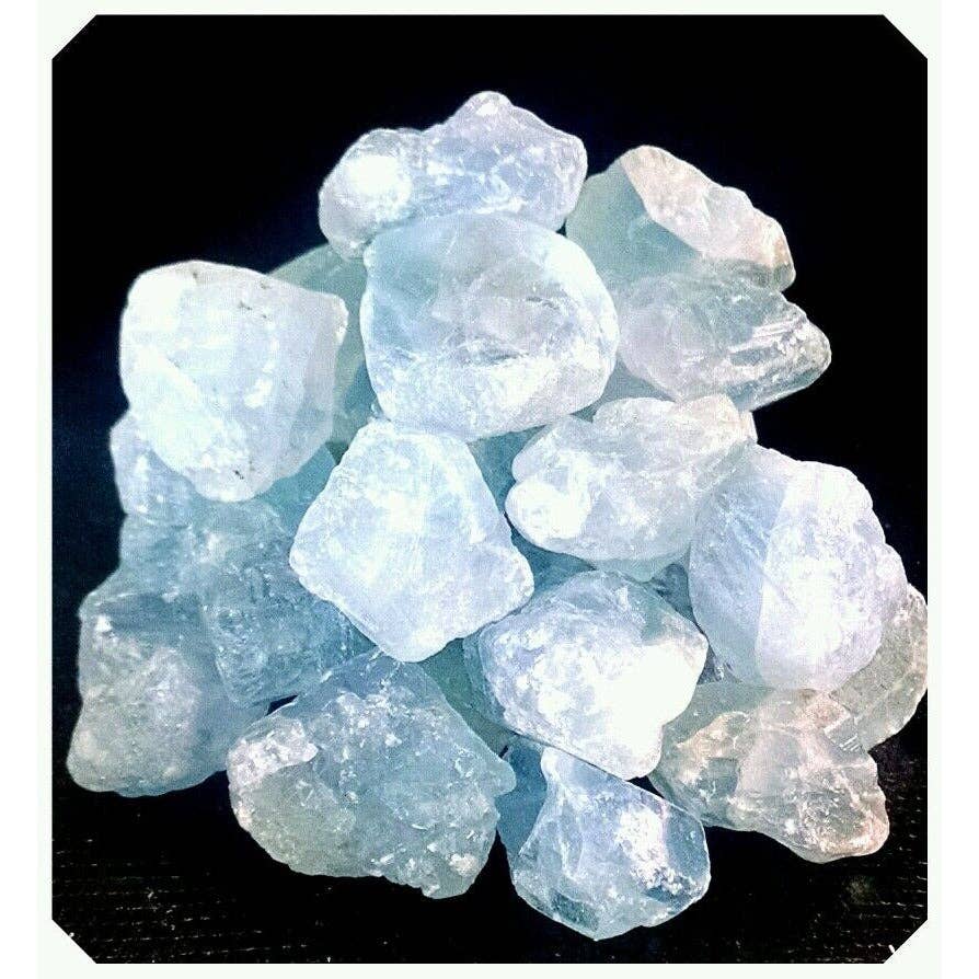 A pile of rough, translucent light blue and white gemstone chips or crystals on a black background.