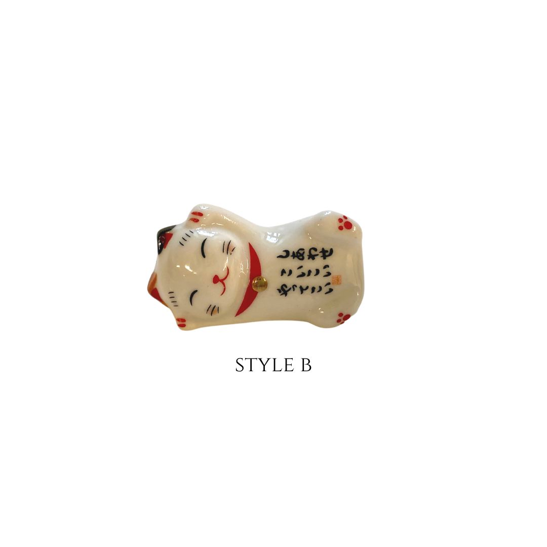 Ceramic cat-shaped object with black text on a white background