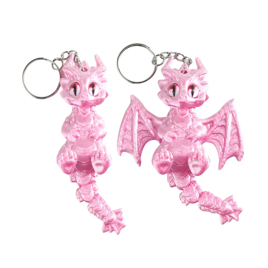 Two pink dragon keychains with silver metal key rings, shown against a plain white background.