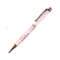Pink pen with rose gold accents on a white background with pink flowers.