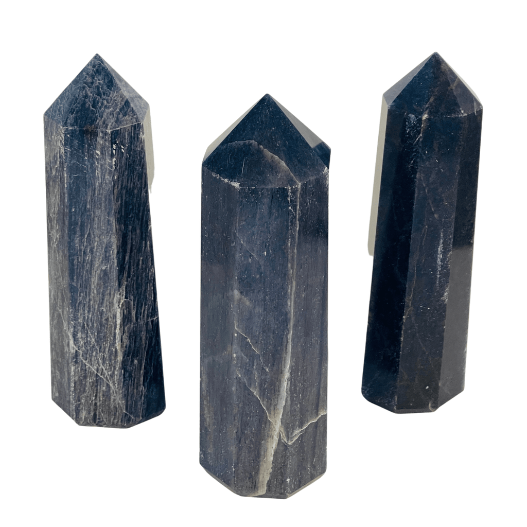 Three dark stone crystal points on a white background