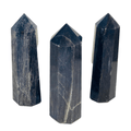 Three dark stone crystal points on a white background