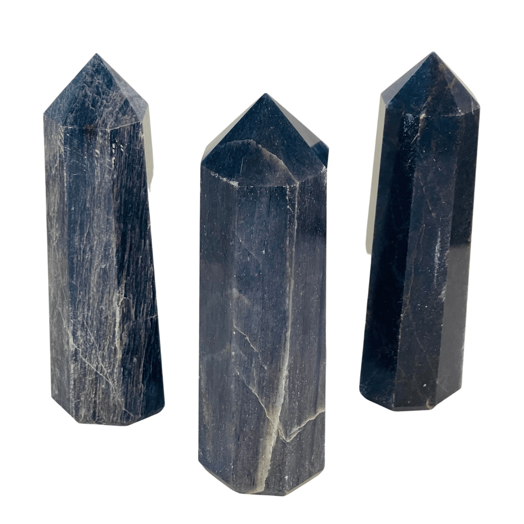 Three dark stone crystal points on a white background