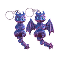 Two small dragon-shaped keychains with silver key rings, shown on a plain white background. The dragons have metallic purple and blue coloring with light blue eyes.