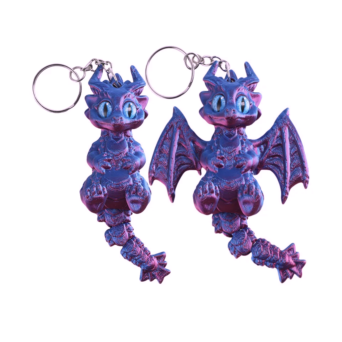 Two small dragon-shaped keychains with silver key rings, shown on a plain white background. The dragons have metallic purple and blue coloring with light blue eyes.