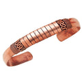 Copper bracelet with intricate designs on a white background