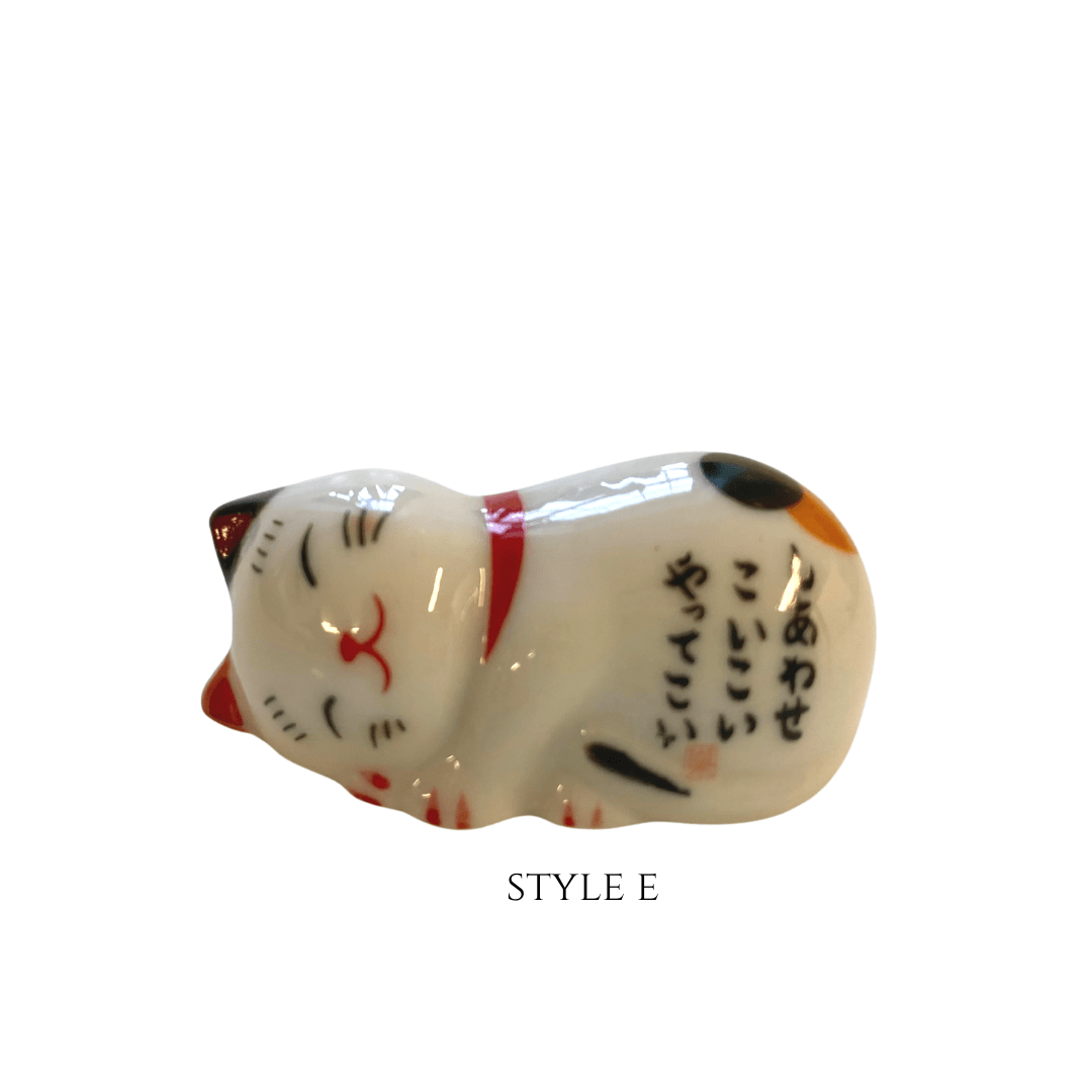 Ceramic cat figurine with black text on a white background