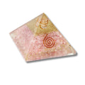 Rose Quartz Orgonitte Pyramid-shaped object with pink and gold design on a white background