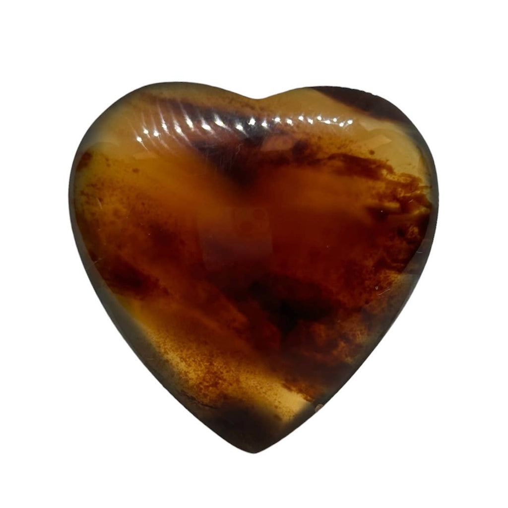 A heart-shaped polished Amber with various brown swirls, shown on a plain white background.
