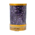 A cylindrical diffuser filled with purple amethyst tumbled stones, featuring a natural wood-grain top and bottom base with a silver metal band and control buttons.