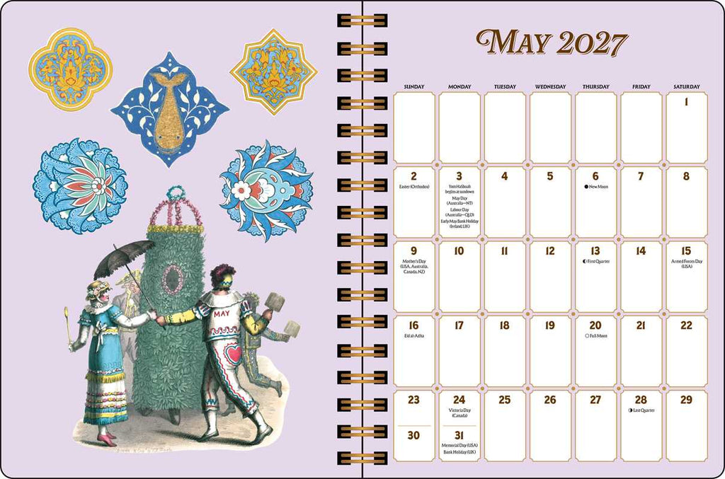 A May 2027 spiral-bound calendar page with decorative vintage illustrations on a pale lavender background. The left side shows ornate blue and gold motifs, a woman with an umbrella, and a large green tent; the right side shows the monthly calendar grid with blank date boxes.