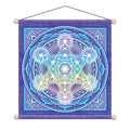 A square hanging wall tapestry featuring a colorful geometric sacred geometry design on a purple background, suspended by a black cord with wooden finials at the corners.