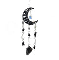 Decorative hanging suncatcher with black obsidian crescent moon, crystals, and stars on a white background