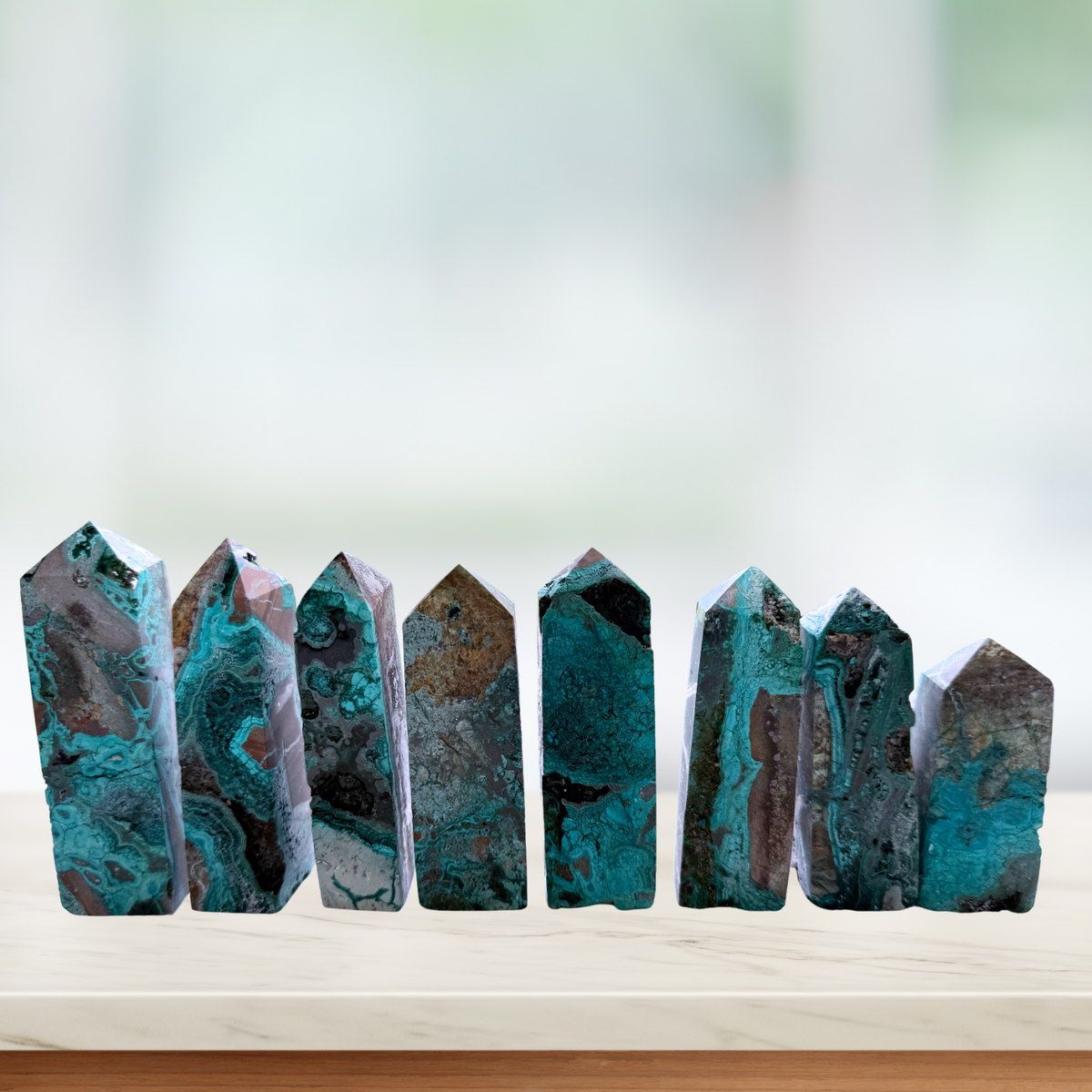 Chrysocolla Obelisk Specimens of varying heights lined up in a window sill