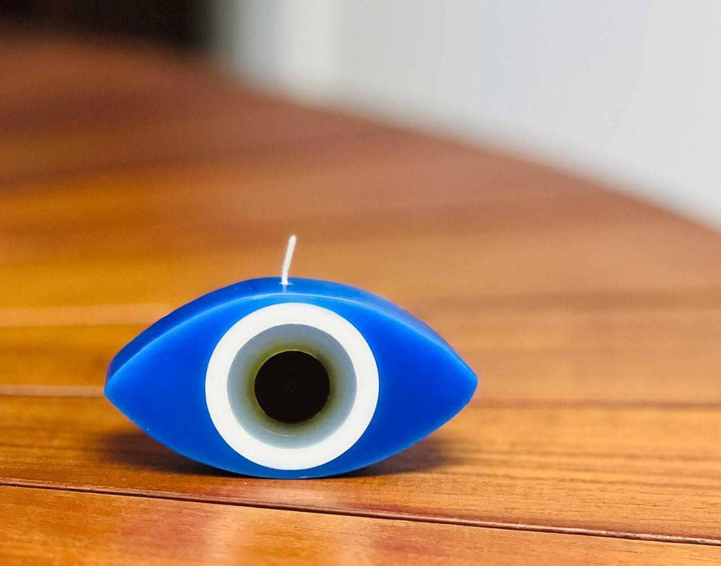 Blue eye-shaped candle on a wooden surface