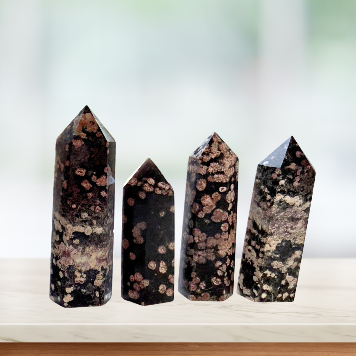 Four Red Snowflake Obsidian Points in a window sill