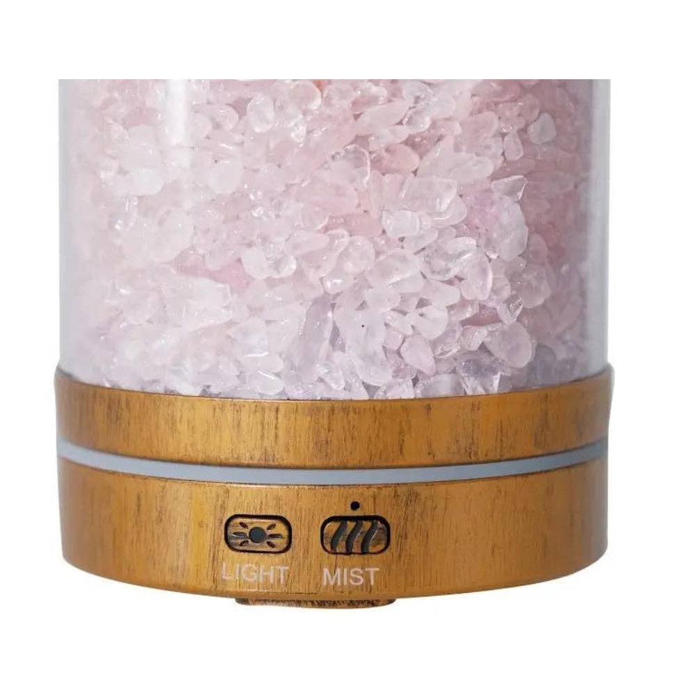 Himalayan salt lamp with wooden base and pink crystals on a white background