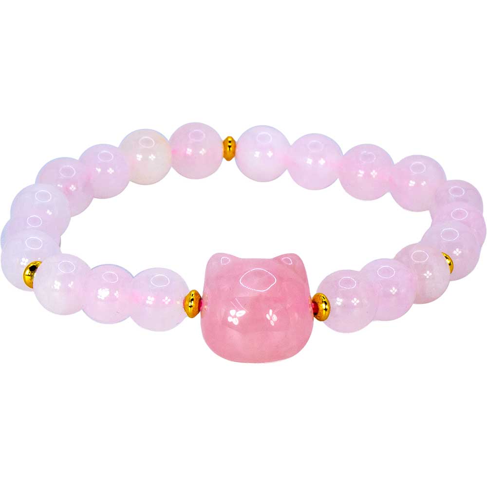 A pink beaded bracelet featuring a central faceted pink stone bead shaped like a cat head, accented by small gold spacer beads on a white background.