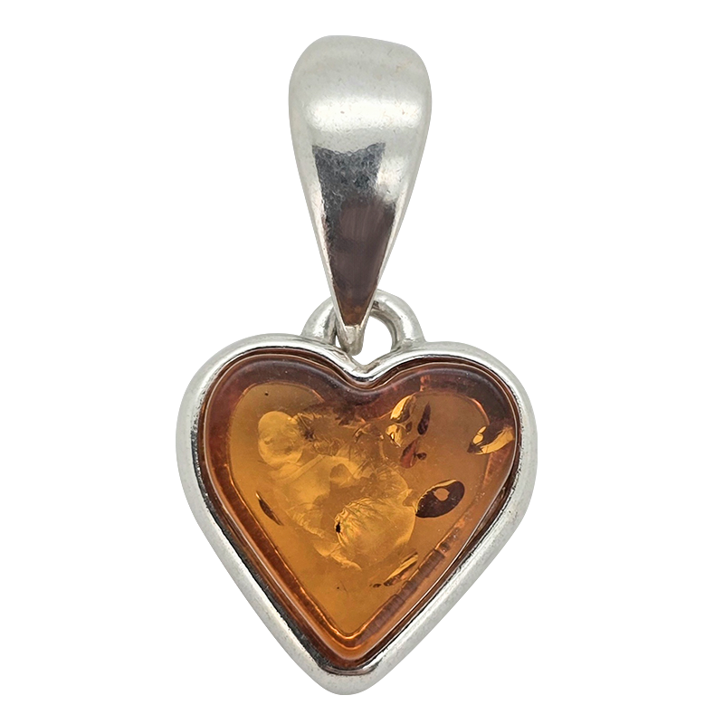 A heart-shaped pendant featuring a polished amber-colored center with visible inclusions, set in a silver-toned metal bezel with a matching silver bail, shown on a plain white background.