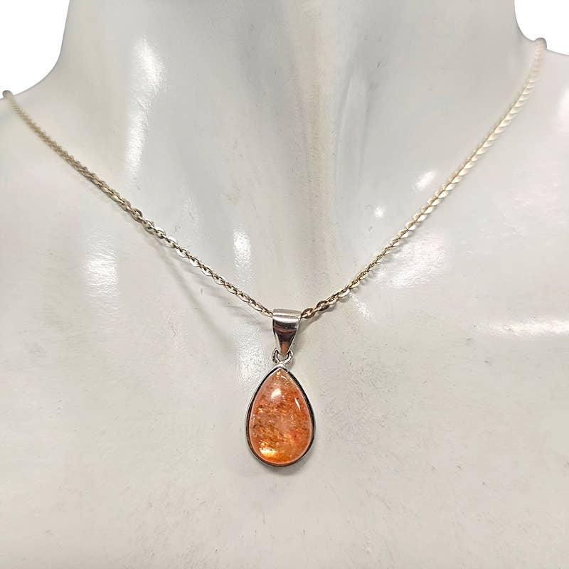 A silver chain necklace with a teardrop-shaped Sunstone pendant, displayed on a white mannequin bust.