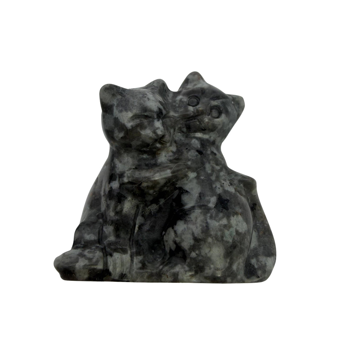 A carved stone figurine of two cats embracing, made from a speckled gray and white yooperlite stone, photographed on a plain light gray background.