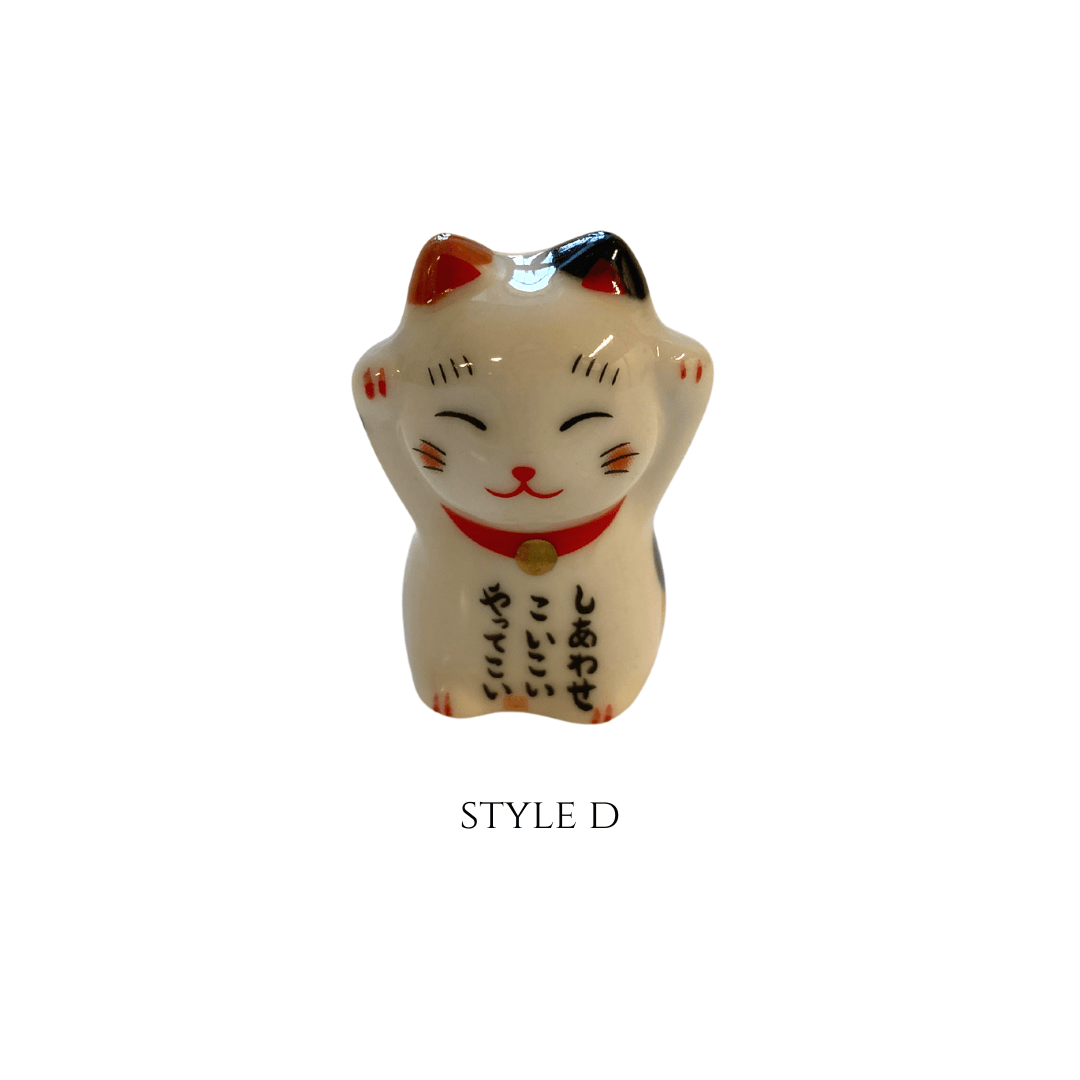 White cat-shaped figurine with red accents on a white background, labeled 'STYLE D'.