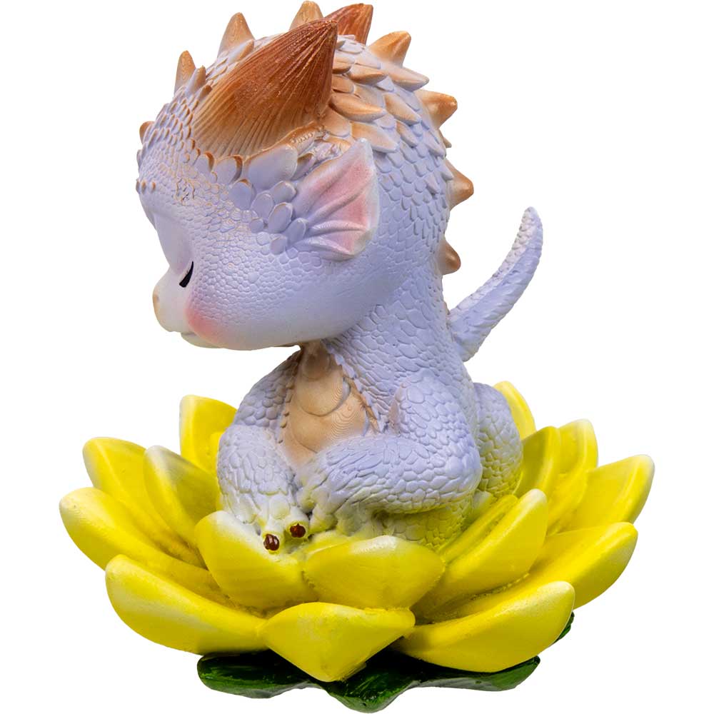 Dragon figurine with orange mane on a yellow lotus flower against a white background