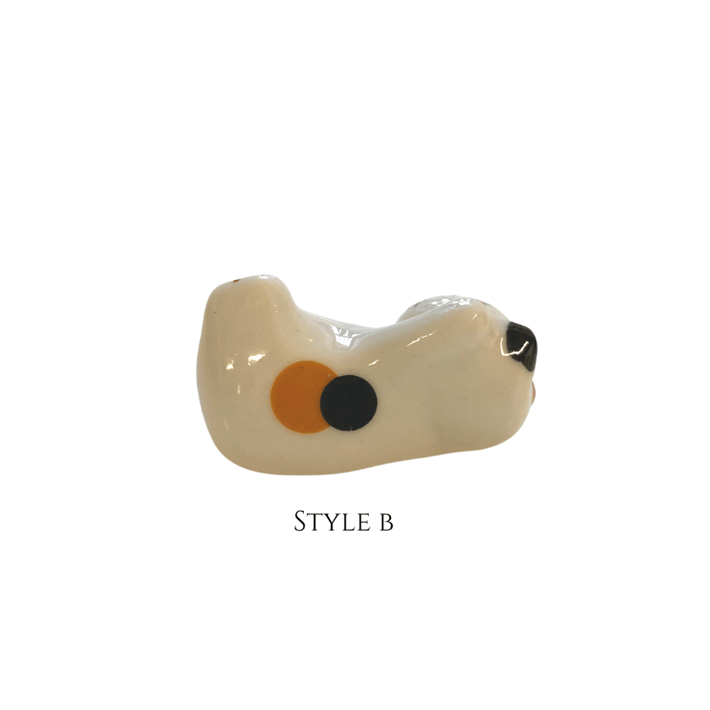 Glass pipe with a white base, orange circle, and black dot on a white background