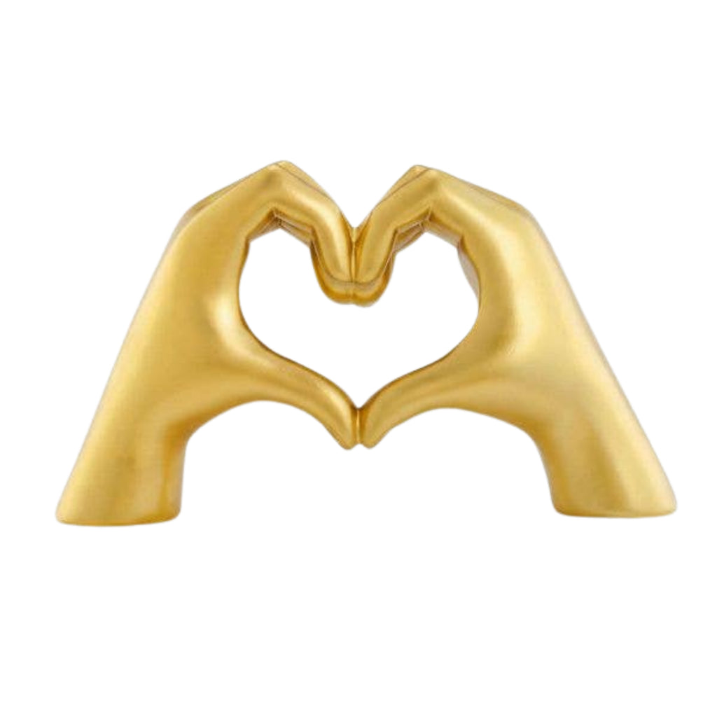 Gold sculpture of two hands forming a heart shape on a white background
