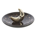 Black dish with a gold crescent moon on a white background