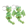 Two green dragon keychains with silver metal key rings, shown against a plain white background.