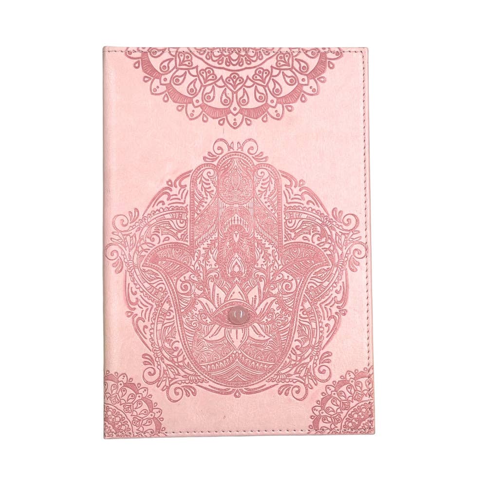 A pink notebook or journal cover featuring an embossed Hamsa hand design with an eye of providence in the center and ornate mandala patterns at the top and bottom, shown against a plain white background.