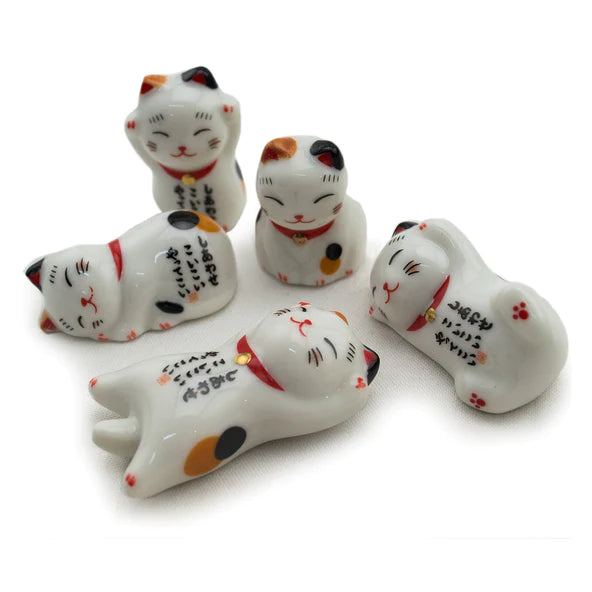 Five ceramic cat figurines with black, orange, and red accents on a white background